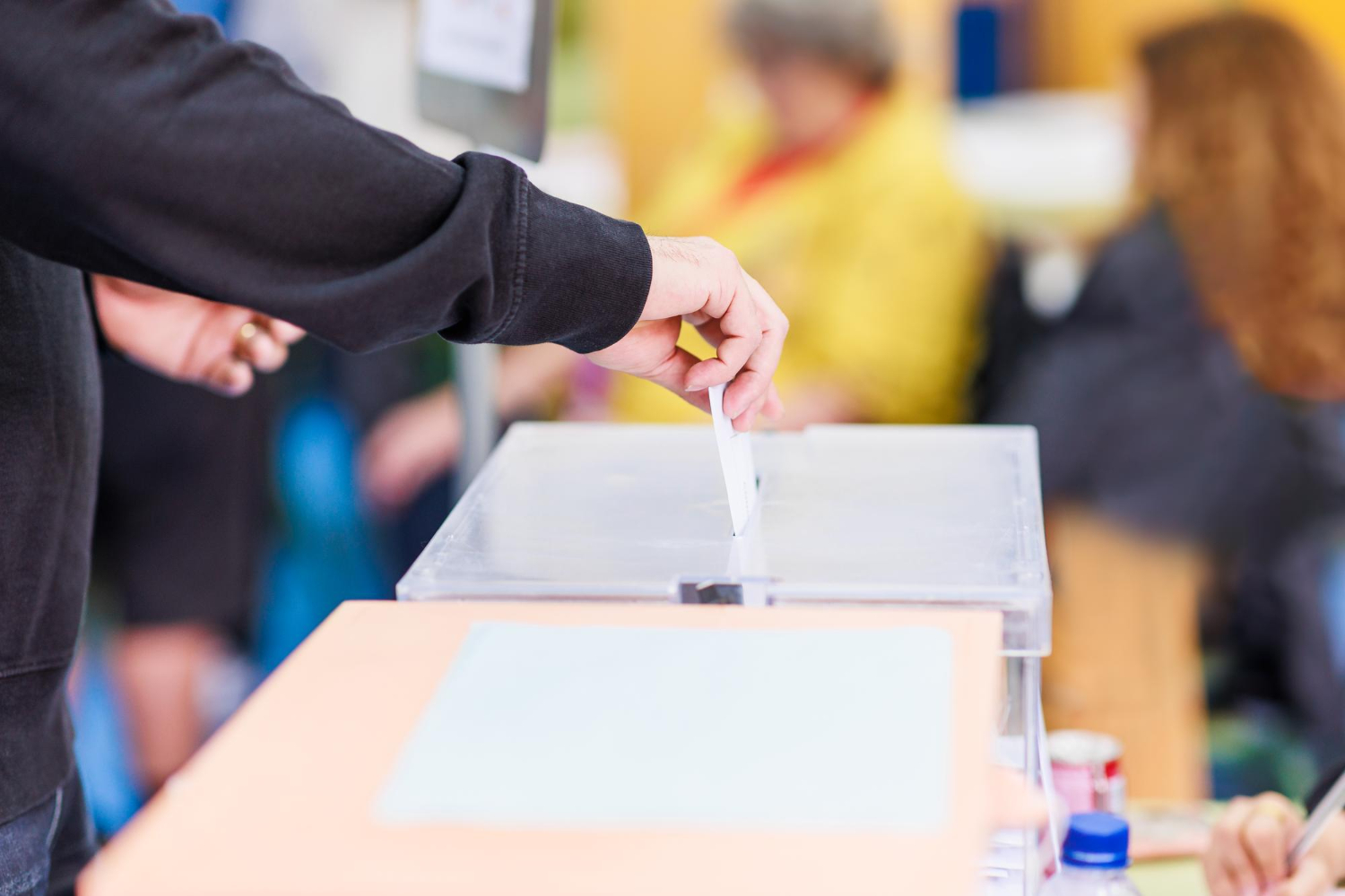 Une personne mettant un bulletin dans une urne électorale.