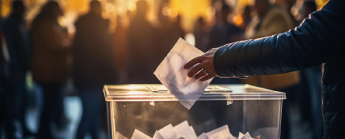Une personne mettant un bulletin dans une boîte de vote.