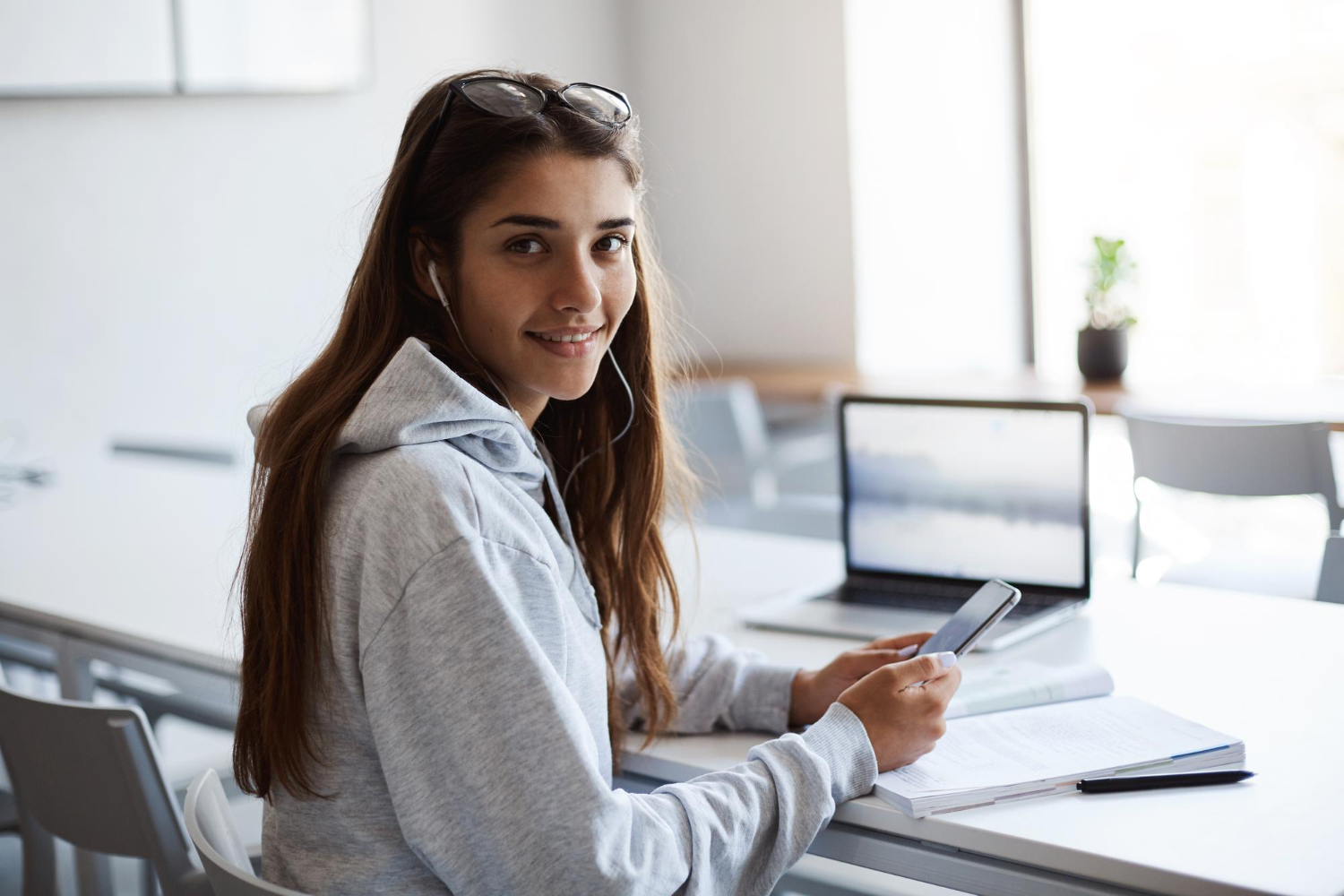 Etudiante souriante travaillant sur un ordinateur portable.