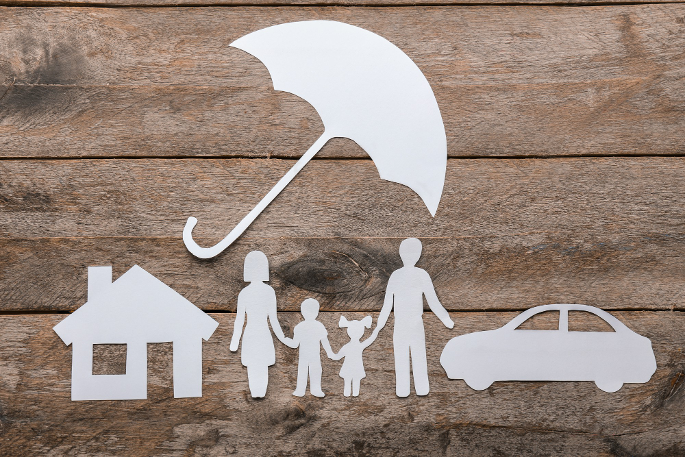 Silhouette en papier de famille, parapluie, maison et voiture sur une surface en bois. Concept d'assurance-vie.