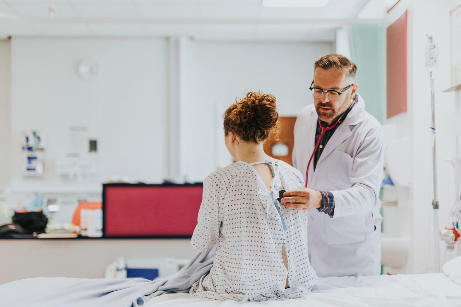 Médecin auscultant une patiente avec son stéthoscope à l'hôpital.