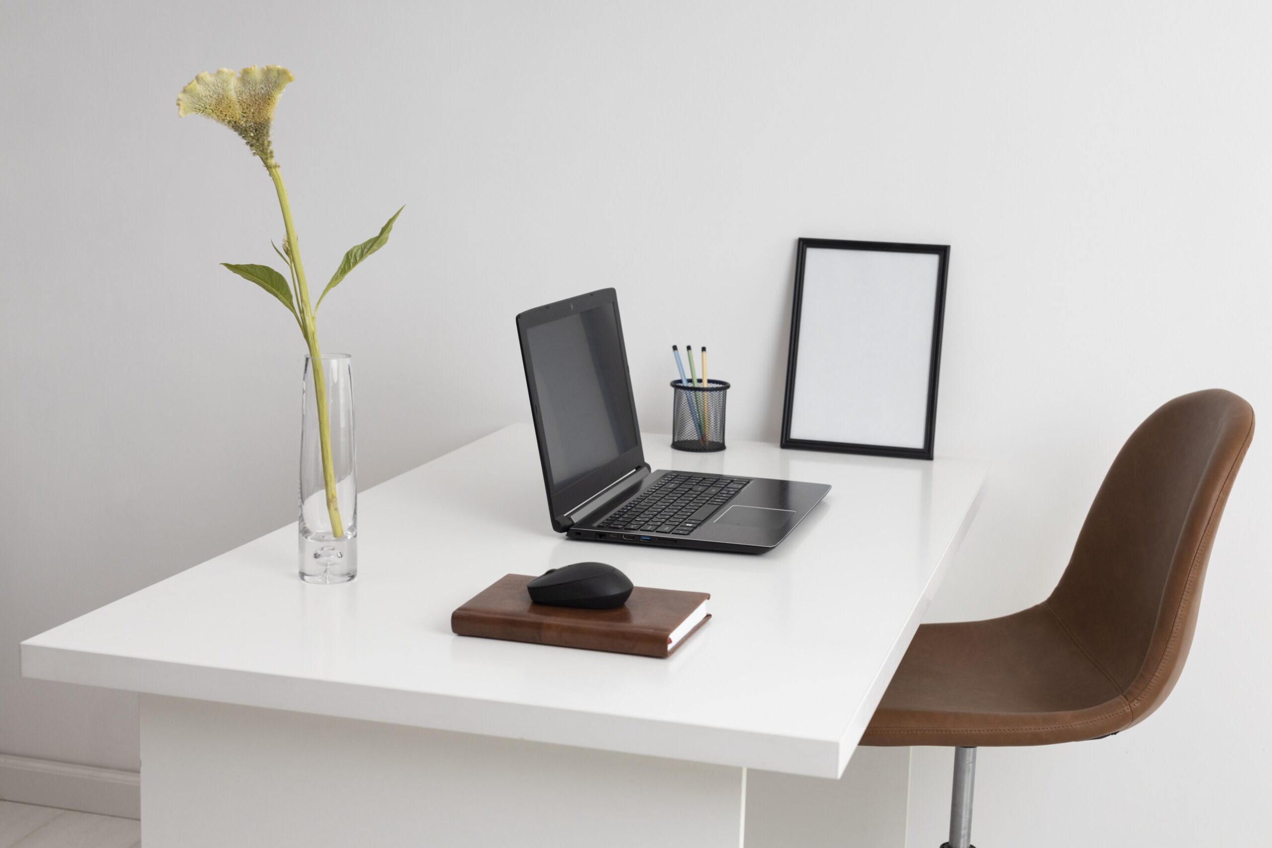 Bureau design avec une chaise, un ordinateur portable, un cahier.