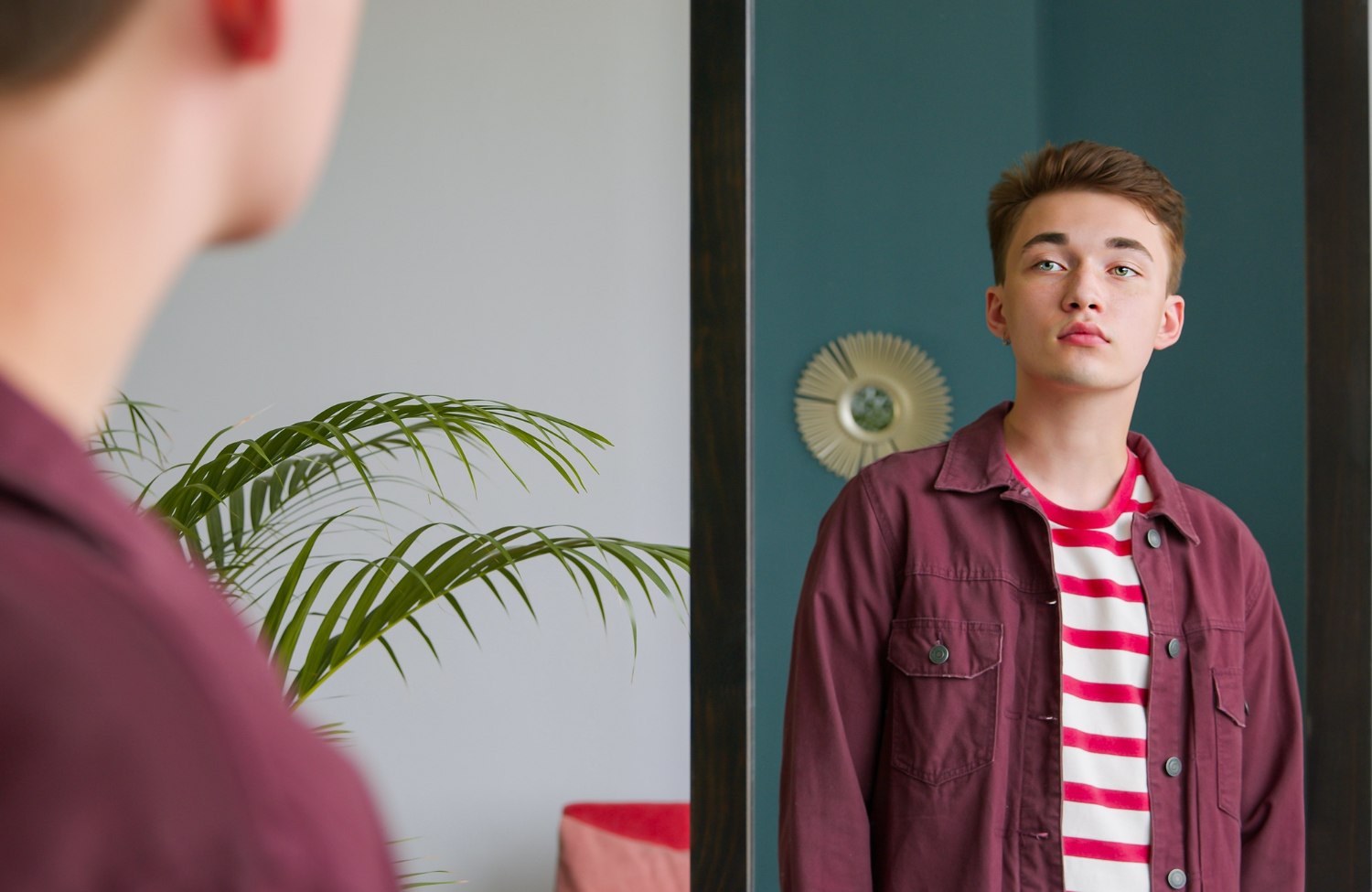 Jeune ado qui regarde son reflet dans un miroir.