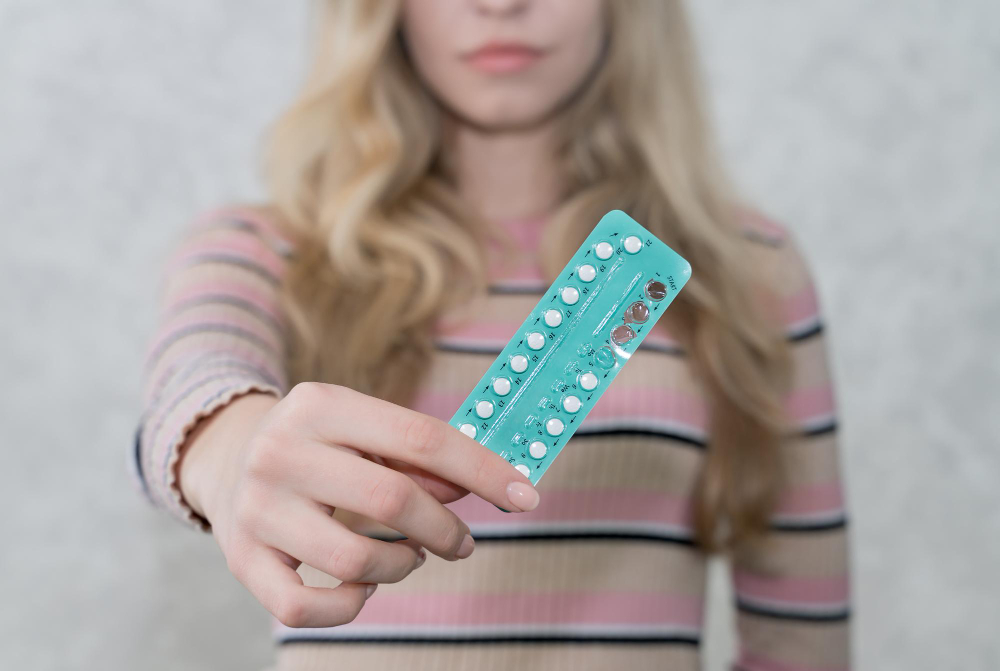 Fille tenant une plaquette de pilules contraceptives dans ses mains. 