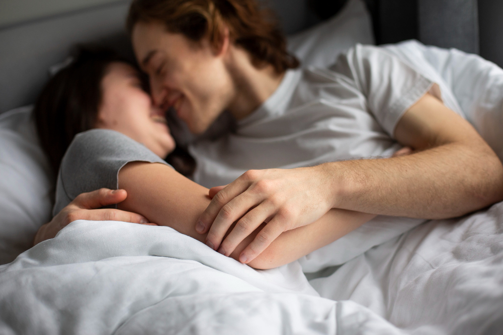 Couple s'embrassant dans le lit.