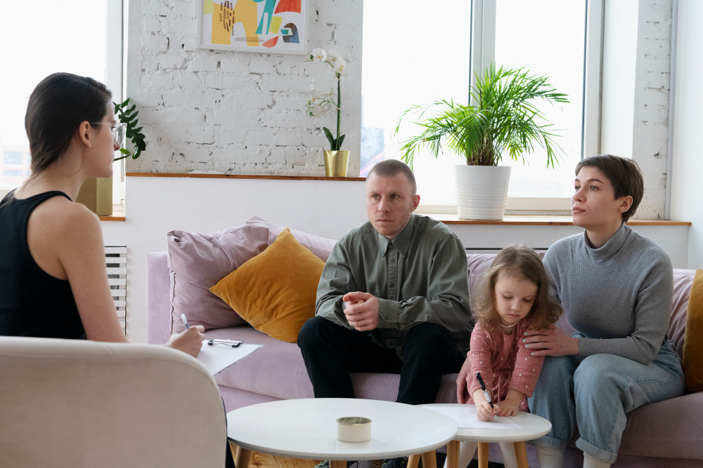 Parents et enfant qui discutent avec une conseillère dans un bureau.