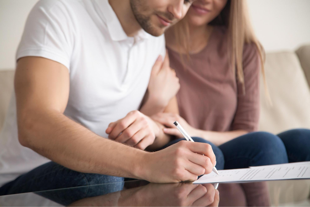 Un couple qui signe un papier.