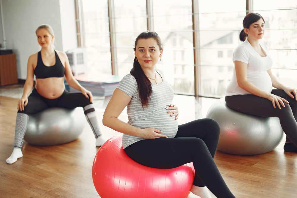 Femmes enceintes faisant du yoga dans une salle de sport.