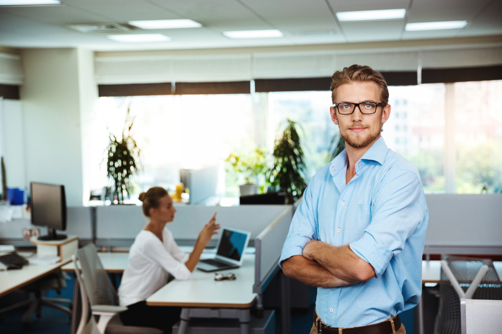 Homme souriant debout dans un bureau d'entreprise.